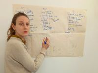 A young woman, Blandine Renault, writes on a whiteboard
